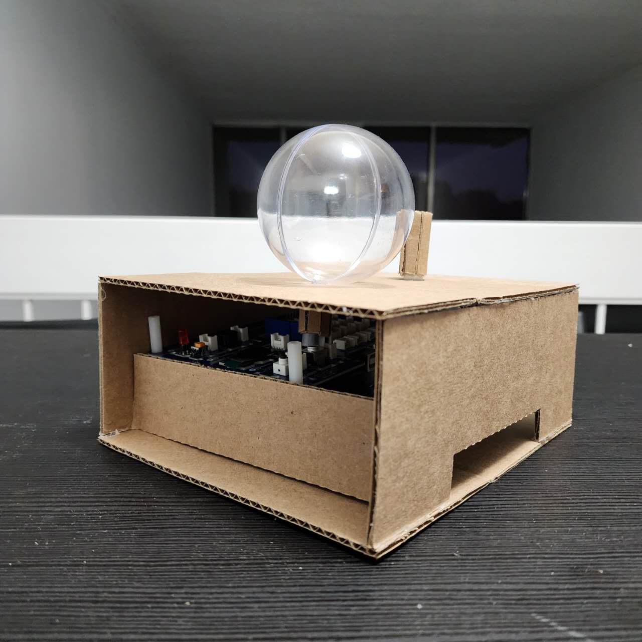 Side view of the final prototype showing the placement of the knobs and the moon ornament knob on the top. And a hole cut underneath for the USB cable to connect to the Arduino.